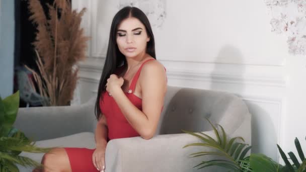 Mignon jeune femme caucasienne modèle brunette en robe rouge — Video