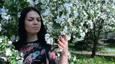 bahar çiçekleri beyaz bir elma bahçesi içinde yürüyen genç mutlu kadın. Güzel bir kız portresi