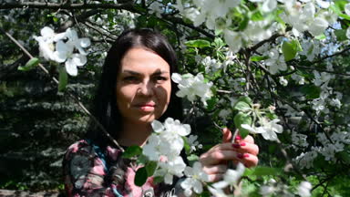 bahar çiçekleri beyaz bir elma bahçesi içinde yürüyen genç mutlu kadın. Güzel bir kız portresi