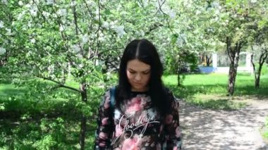 bahar çiçekleri beyaz bir elma bahçesi içinde yürüyen genç mutlu kadın. Güzel bir kız portresi