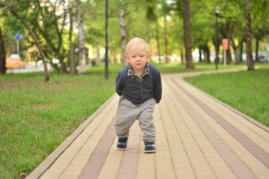 küçük bir çocuk parkta yürüyor