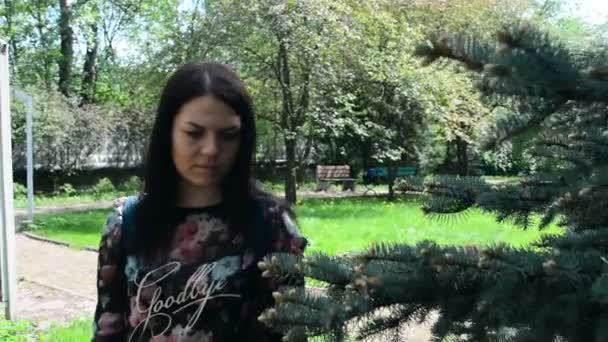 Mulher bonita em um passeio no parque de primavera — Vídeo de Stock