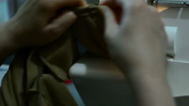 O kumaş keser ve bir makinede diker gibi bir dikiş proje üzerinde çalışan bir kadın. dikiş makinesi yakın bir bez dikiş sırasında bir makinede destekleyen bir terzi bir el kadar.