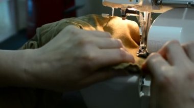 O kumaş keser ve bir makinede diker gibi bir dikiş proje üzerinde çalışan bir kadın. dikiş makinesi yakın bir bez dikiş sırasında bir makinede destekleyen bir terzi bir el kadar.
