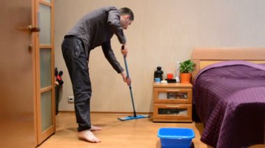 Genç bir adam bir paspas kat yıkar