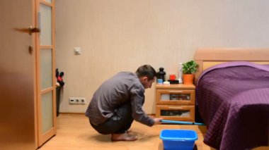 Genç bir adam bir paspas kat yıkar