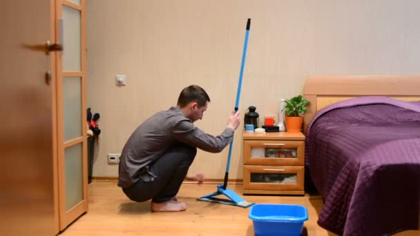 Een Jonge Man Wast Een Mop Vloeren — Stockvideo