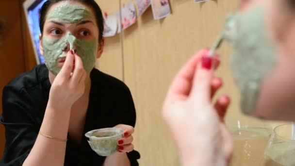 Menina Aplicando Máscara Cosmética Barro Azul Sala Frente Espelho — Vídeo de Stock