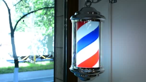 Kapper paal draait op de muur in de kapsalon. Barber pole draait in de kapperszaak. Vintage kapperszaak en kapperssymbool. Traditionele kapperspaal draaiend in kapperszaak — Stockvideo