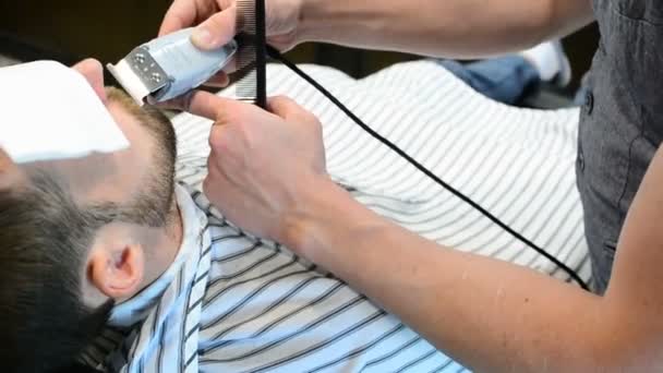 Чоловіча зачіска і стрижка в перукарні або перукарні. Вирощування бороди. Перукарня. Чоловік перукар робить зачіску бороди дорослих чоловіків у чоловічому перукарні. Перукарі на робочому місці — стокове відео