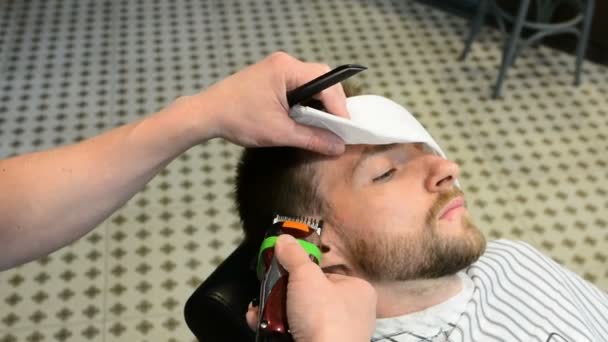 Penteado masculino e corte de cabelo em uma barbearia ou salão de cabeleireiro. A arrumar a barba. Barbearia. Homem cabeleireiro fazendo barba de corte de cabelo homens adultos no salão de cabeleireiro dos homens. Cabeleireiros no local de trabalho — Vídeo de Stock