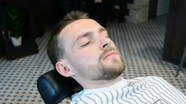 Kuaför kesim istemcileri sakal profesyonel sakal düzeltici bir berber dükkanı açık renkli, tarih içinde yakın çekim.