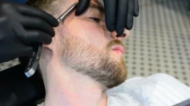 Ustura ile tıraş sakal kesmek. Kuaför dükkanı tıraş sakal, yakın çekim. Erkek sakal tarzı. Tıraş hipster adam yüz berber