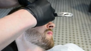 Ustura ile tıraş sakal kesmek. Kuaför dükkanı tıraş sakal, yakın çekim. Erkek sakal tarzı. Tıraş hipster adam yüz berber