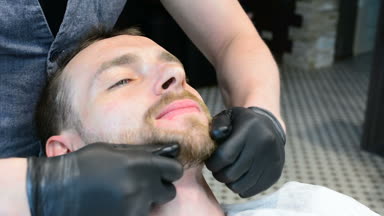 Ustura ile tıraş sakal kesmek. Kuaför dükkanı tıraş sakal, yakın çekim. Erkek sakal tarzı. Tıraş hipster adam yüz berber