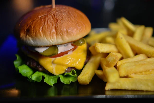 Lezzetli hamburger, patates kızartması sosu kara tahta üzerinde