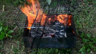 Ahşap, kağıt ve metal mangal kömür ızgara yanan, ısınma, sıcak kamp ateşi üzerinde pişirme Barbekü, iyi piknik arka plan olarak önce parlak kırmızı ve turuncu renklerde parlayan