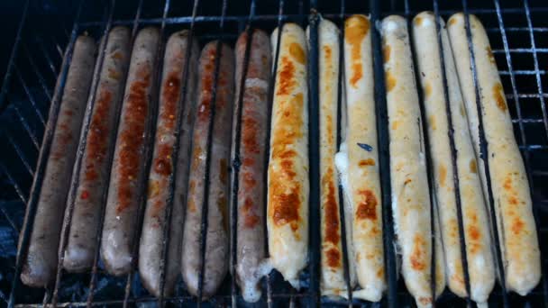 Барбекю жареные колбасы на горячем гриле, человек поворачивается и положить на жаровню — стоковое видео