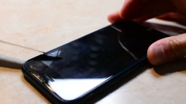 Kırık güvenlik camı mobil telefon yeni adam değişiklikleri. Yeni bir koruyucu cam telefonda yapışır. Yakın çekim yakışıklı.