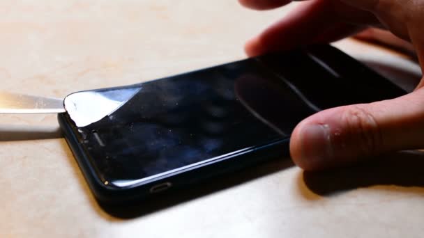 人类改变了手机的破裂安全玻璃的新 在电话上贴一个新的防护玻璃 特写手 — 图库视频影像