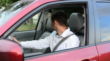 Arabasının içinde bekleyen ve hayal kırıklığı belirtileri gösteren sabırsız olmak genç sürücü.