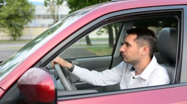 Park boyunca giden adam yerleştirin ve arabasını ve gidiyor oturur. Erkek açık arabanın kapı kaldırmak sinyal