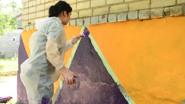 Girl Paints Brick Wall Patterns Yellow Purple — Stock Video