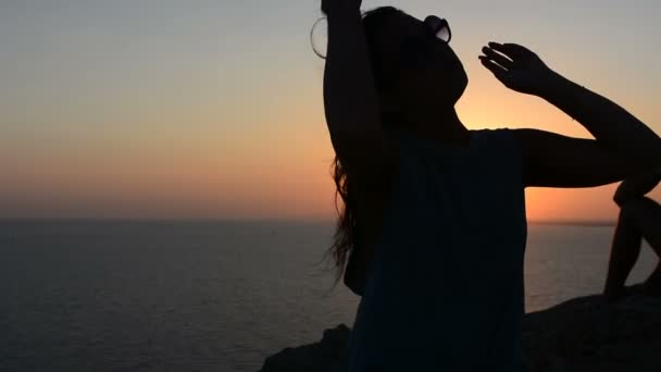 Meisje roken sigaret bij zonsondergang in de buurt van de zee — Stockvideo