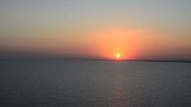 Günbatımı denize. Havadan görünümü: arka plan turuncu gökyüzü ve Adaları deniz üzerinden günbatımı. Okyanus üzerinde günbatımı zamanında sinek. Seyahat kavramı. Sadece gökyüzü, bulutlar ve su. Güzel sakin