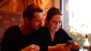 Akıllı telefon internet tarama kafede genç Çift