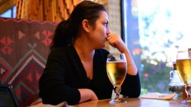 Bir kız bir bardak bira içiyor. Bir bardak bira tablodur. Bir bira bar bir lokanta var mı.