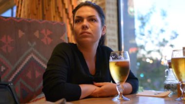 Bir kız bir bardak bira içiyor. Bir bardak bira tablodur. Bir bira bar bir lokanta var mı.