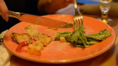 Sezar salata kırmızı maşa, parmesan peyniri, sos, plaka üzerinde makro closeup maşa, hareketli, arka planda yeme insanlar