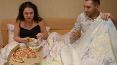 Çift pizza teslim yeme yatakta