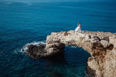 Genç gelin ve damat sahilde yürüyüş, Öpüşme ve sahip eğlenceli, düğün töreni kayalar ve deniz yakınında gülümseyen güzel. Kıbrıs Sahil düğün töreni