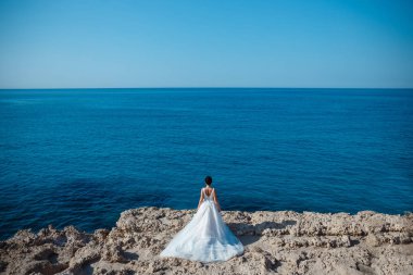 Genç gelin ve damat sahilde yürüyüş, Öpüşme ve sahip eğlenceli, düğün töreni kayalar ve deniz yakınında gülümseyen güzel. Kıbrıs Sahil düğün töreni
