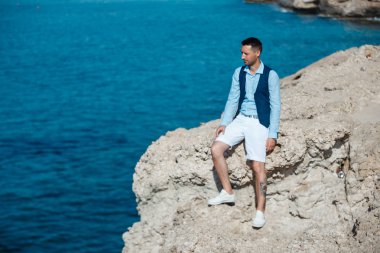 Genç gelin ve damat sahilde yürüyüş, Öpüşme ve sahip eğlenceli, düğün töreni kayalar ve deniz yakınında gülümseyen güzel. Kıbrıs Sahil düğün töreni