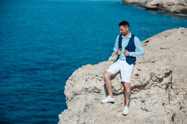 Genç gelin ve damat sahilde yürüyüş, Öpüşme ve sahip eğlenceli, düğün töreni kayalar ve deniz yakınında gülümseyen güzel. Kıbrıs Sahil düğün töreni