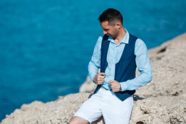 Genç gelin ve damat sahilde yürüyüş, Öpüşme ve sahip eğlenceli, düğün töreni kayalar ve deniz yakınında gülümseyen güzel. Kıbrıs Sahil düğün töreni