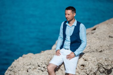 Genç gelin ve damat sahilde yürüyüş, Öpüşme ve sahip eğlenceli, düğün töreni kayalar ve deniz yakınında gülümseyen güzel. Kıbrıs Sahil düğün töreni