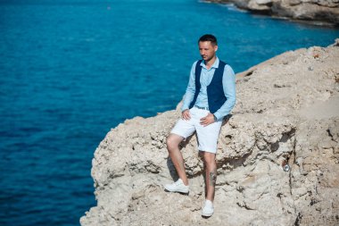 Genç gelin ve damat sahilde yürüyüş, Öpüşme ve sahip eğlenceli, düğün töreni kayalar ve deniz yakınında gülümseyen güzel. Kıbrıs Sahil düğün töreni