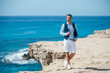 Genç gelin ve damat sahilde yürüyüş, Öpüşme ve sahip eğlenceli, düğün töreni kayalar ve deniz yakınında gülümseyen güzel. Kıbrıs Sahil düğün töreni