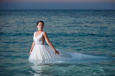 Genç gelin ve damat sahilde yürüyüş, Öpüşme ve sahip eğlenceli, düğün töreni kayalar ve deniz yakınında gülümseyen güzel. Kıbrıs Sahil düğün töreni