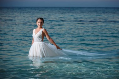 Genç gelin ve damat sahilde yürüyüş, Öpüşme ve sahip eğlenceli, düğün töreni kayalar ve deniz yakınında gülümseyen güzel. Kıbrıs Sahil düğün töreni