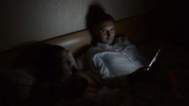 Young Couple Smartphone Tablet Lying Bed Late Night Home — Stock Video