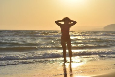 Kırmızı bir mayo içinde sahilde poz güzel mutlu esmer kız.