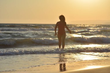 Kırmızı bir mayo içinde sahilde poz güzel mutlu esmer kız.