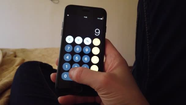 Zakenman thuis in bed acht calculator op de telefoon — Stockvideo