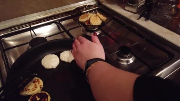 Jovem mulher faz panquecas de queijo cottage no fogão de cozinha — Vídeo de Stock