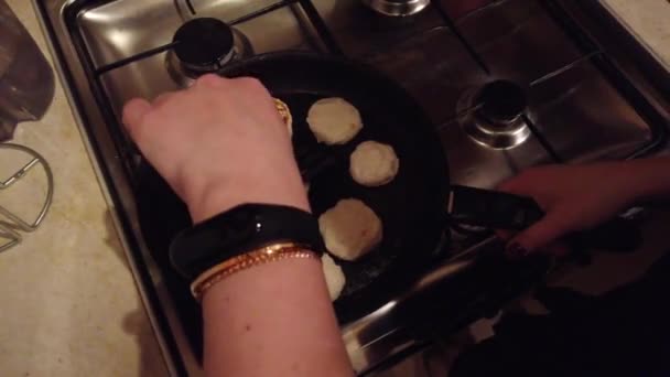 La giovane donna fa frittelle di fiocchi di latte a stufa di cucina — Video Stock